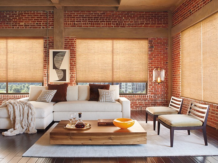 A living room with windows featuring Provenance® Woven Wood Shades Fabric: Jute Forest  Color: Sycamore